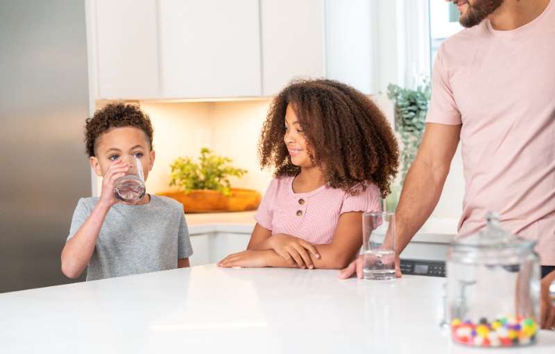 Children enjoying clean, filtered drinking water in the kitchen